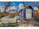 Charming blue shed with white trim and a picket fence, adding character to the property at 12821 W 60Th Ave, Arvada, CO 80004
