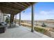 Covered back patio featuring elegant outdoor furniture with views of a grass backyard and neighboring houses at 26741 E Peakview Pl, Aurora, CO 80016