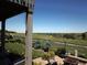 Relaxing backyard with covered patio, manicured lawn, garden beds and view of open land and small lake at 26741 E Peakview Pl, Aurora, CO 80016