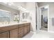 Bathroom with double sink vanity, marble counters, and access to a large walk-in closet at 26741 E Peakview Pl, Aurora, CO 80016