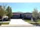 Beautiful single-story home with a large concrete driveway, well-manicured lawn, and professional landscaping at 26741 E Peakview Pl, Aurora, CO 80016