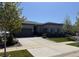 Charming single-story home with a meticulously maintained lawn, professional landscaping, and a paved concrete driveway at 26741 E Peakview Pl, Aurora, CO 80016