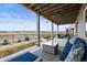 Relaxing outdoor patio featuring comfortable seating, a glass coffee table, and scenic views of the neighborhood at 26741 E Peakview Pl, Aurora, CO 80016