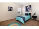 Cozy bedroom with turquoise bedding, and vibrant art at 7222 Aspen Brook Ave, Frederick, CO 80530
