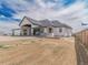 Rear view of a stylish home with a covered patio, large windows, and a partially seeded lawn at 29585 E 165Th Ave, Brighton, CO 80603