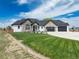 Charming home featuring stone accents, a well-manicured lawn, and a spacious three-car garage at 29585 E 165Th Ave, Brighton, CO 80603