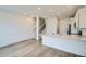 Modern kitchen with stainless steel appliances, white cabinets, and breakfast bar at 700 N Bently St, Watkins, CO 80137