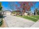 Charming single-story home featuring a long driveway, detached garage and mature trees in a landscaped front yard at 4625 S Huron St, Englewood, CO 80110
