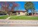 Inviting single-story home with brick accents, mature trees, and a well-manicured lawn at 4625 S Huron St, Englewood, CO 80110