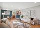 Sun-filled living room featuring hardwood floors, modern decor, and a seamless flow to the dining area and kitchen at 4625 S Huron St, Englewood, CO 80110