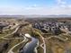 Drone view of a neighborhood with walking paths, pond, and open green space with mountain backdrop at 12242 W 56Th Pl, Arvada, CO 80002
