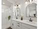 Modern bathroom with double vanity, sleek fixtures, arched mirrors, and glass-enclosed walk-in shower at 12242 W 56Th Pl, Arvada, CO 80002