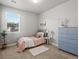 Cozy bedroom with window view, a pink bed, a soft rug and a blue dresser with silver handles at 12242 W 56Th Pl, Arvada, CO 80002