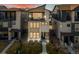 Modern two-story home with stone accents, a balcony, manicured lawn, and beautiful landscaping at 12242 W 56Th Pl, Arvada, CO 80002