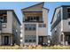 Three-story home with balcony and stone accents nestled between similar modern homes at 12242 W 56Th Pl, Arvada, CO 80002