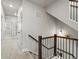 Bright hallway with neutral carpet and staircase featuring wooden handrail and black metal spindles at 12242 W 56Th Pl, Arvada, CO 80002