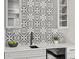 Close-up of wet bar featuring black and white patterned backsplash and gray cabinets at 12242 W 56Th Pl, Arvada, CO 80002