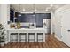 Spacious kitchen with navy cabinets, stainless steel appliances, and a breakfast bar with seating at 12242 W 56Th Pl, Arvada, CO 80002