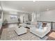 Bright living room featuring a large sectional couch, ottoman, and a stylish patterned area rug at 12242 W 56Th Pl, Arvada, CO 80002