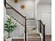 Modern staircase with carpeted steps, a dark wood railing, and stylish wall decor at 12242 W 56Th Pl, Arvada, CO 80002
