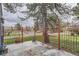 Fenced backyard with trees, grass, and a concrete patio at 7957 Elm St, Louviers, CO 80131