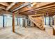 Spacious unfinished basement with exposed beams and staircase at 7957 Elm St, Louviers, CO 80131