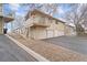 Two-story home with three garage doors and a balcony under a partly cloudy sky at 2285 Coronado Pkwy # D, Denver, CO 80229