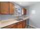 Traditional kitchen with double sink, wood cabinets, and view from window at 2285 Coronado Pkwy # D, Denver, CO 80229