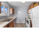 Galley kitchen featuring white appliances, wood cabinets, and gray walls at 2285 Coronado Pkwy # D, Denver, CO 80229