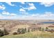 A serene aerial view of a sprawling property, showcasing vast landscapes and a tranquil lake in the background at 7615 Lemon Gulch Way, Castle Rock, CO 80108