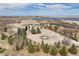 Stunning aerial view of the home, fountain, and surrounding landscape with lake views at 7615 Lemon Gulch Way, Castle Rock, CO 80108