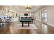 Spacious game room with hardwood floors, multiple ceiling fans, bar, and access to outdoor space at 7615 Lemon Gulch Way, Castle Rock, CO 80108