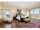 Luxurious main bedroom suite with a large bed, seating area, and windows with expansive views at 7615 Lemon Gulch Way, Castle Rock, CO 80108