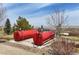 Outdoor photo of two large red fuel or water tanks, a treeline, and distant lake visible at 7615 Lemon Gulch Way, Castle Rock, CO 80108