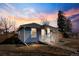 Quaint blue home with a covered front porch and well-maintained yard at dusk at 4846 Knox Ct, Denver, CO 80221