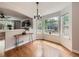 Sunlit dining room featuring hardwood floors, stylish light fixture, and large windows with backyard views at 13244 Kearney St, Thornton, CO 80602