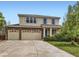 Charming two-story home showcasing a brick facade, three-car garage, landscaped yard, and a welcoming blue front door at 13244 Kearney St, Thornton, CO 80602