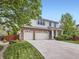 A charming home featuring a brick-accented facade, a spacious three-car garage, and a well-manicured front lawn at 13244 Kearney St, Thornton, CO 80602