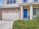 Close-up of a charming home featuring a blue front door, well-maintained landscaping, and a three-car garage at 13244 Kearney St, Thornton, CO 80602