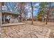 Spacious backyard with a deck, stone patio, mature trees, and privacy fence at 2145 S Lewiston St, Aurora, CO 80013