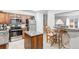 Efficient kitchen with wooden cabinetry, stainless steel appliances, an island, and a view into the dining area at 2145 S Lewiston St, Aurora, CO 80013