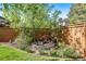 Serene backyard retreat showcasing a charming waterfall feature nestled among lush greenery and mature trees at 5753 S Kittredge St, Centennial, CO 80015