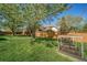 Expansive backyard with lush lawn, mature trees offering shade, and a raised garden for growing vegetables at 5753 S Kittredge St, Centennial, CO 80015