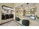 Open-concept view of bar area and kitchen with granite countertops and custom cabinetry at 5753 S Kittredge St, Centennial, CO 80015