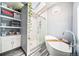 Bright bathroom featuring a skylight, floating shelves and vanity, glass enclosed shower, and stand alone tub at 5753 S Kittredge St, Centennial, CO 80015