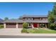 Charming two-story home with a red front door, a three-car garage, and a well-maintained lawn at 5753 S Kittredge St, Centennial, CO 80015