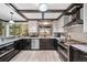 Modern kitchen with a breakfast bar, stainless steel appliances, and dark wood beams at 5753 S Kittredge St, Centennial, CO 80015