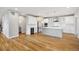 Bright, open kitchen featuring white cabinets, stainless steel appliances, an island, and wooden floors at 779 Kohlor Dr, Lafayette, CO 80026