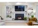 Living room fireplace with a large TV, built-in shelving, and decorative accents at 6219 S Krameria St, Centennial, CO 80111