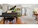 Elegant living room with hardwood floors, a grand piano, large windows, and neutral decor at 6219 S Krameria St, Centennial, CO 80111